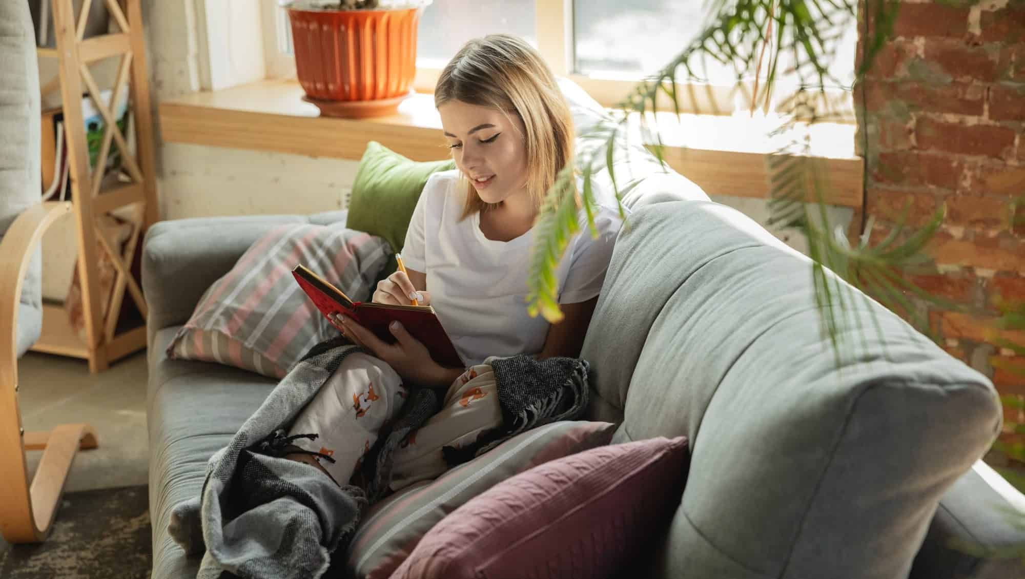 Jente sitter komfortabelt i en sofa